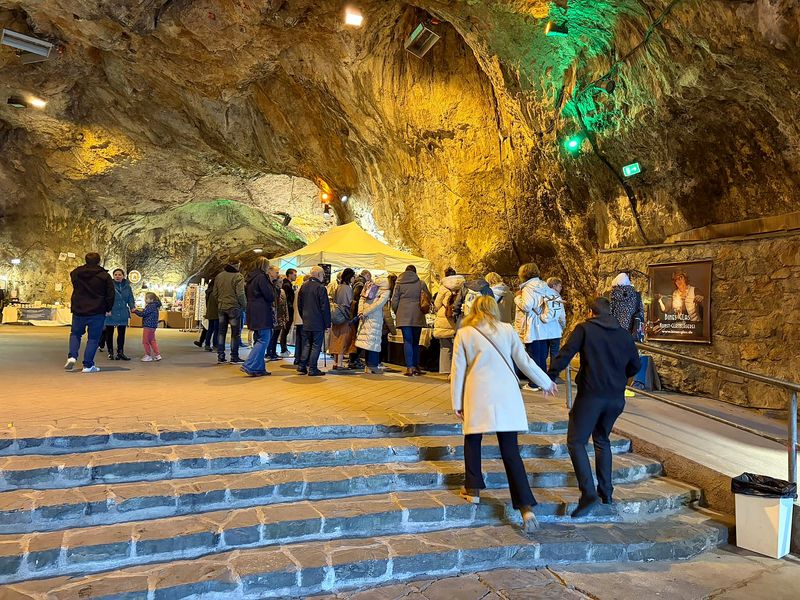 Besucher auf der Treppe in der Höhle, im Hintergrund die Marktstände