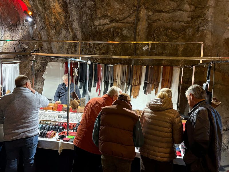 Stand mit Ledergürteln und Geldbörsen, Besucher schauen sich um