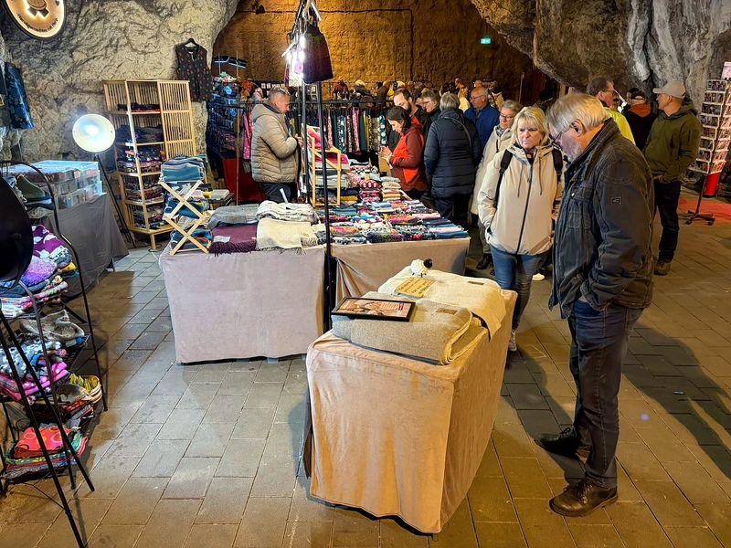Stand mit Wolldecken, Socken und Textilien, Besucher stöbern